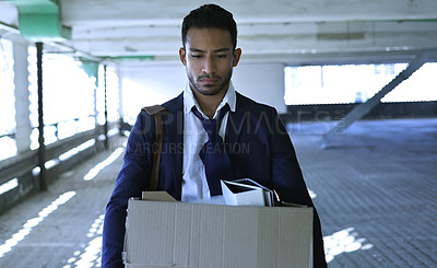 Buy stock photo Cropped shot of a handsome young businessman looking depressed after being retrenched from work