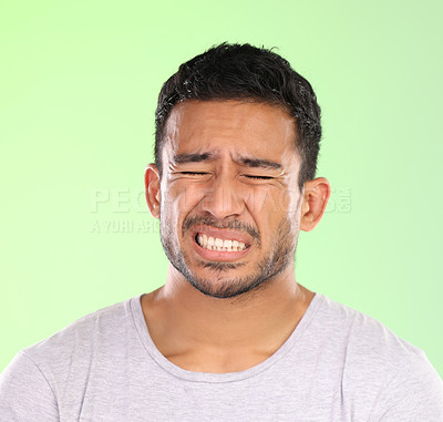 Buy stock photo Man, face and pain or hurt in studio with toothache, gum disease and inflammation with facial expression. Person, emotion or wellness with oral care, healthcare or dental bacteria on green background