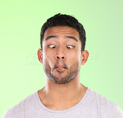 Buy stock photo Man, play and silly in studio, face and goofy comic or funny expression on green background. Male person, mockup space and guy for joke or comedy, student and humor for crazy character and quirky
