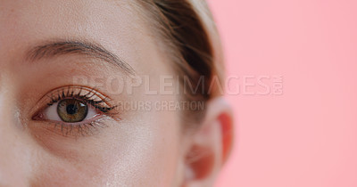 Buy stock photo Cropped studio portrait of a young woman's eye against a pink background