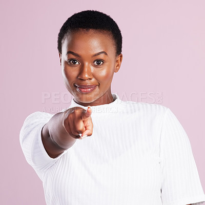 Buy stock photo Studio portrait of a young woman pointing against a pink background