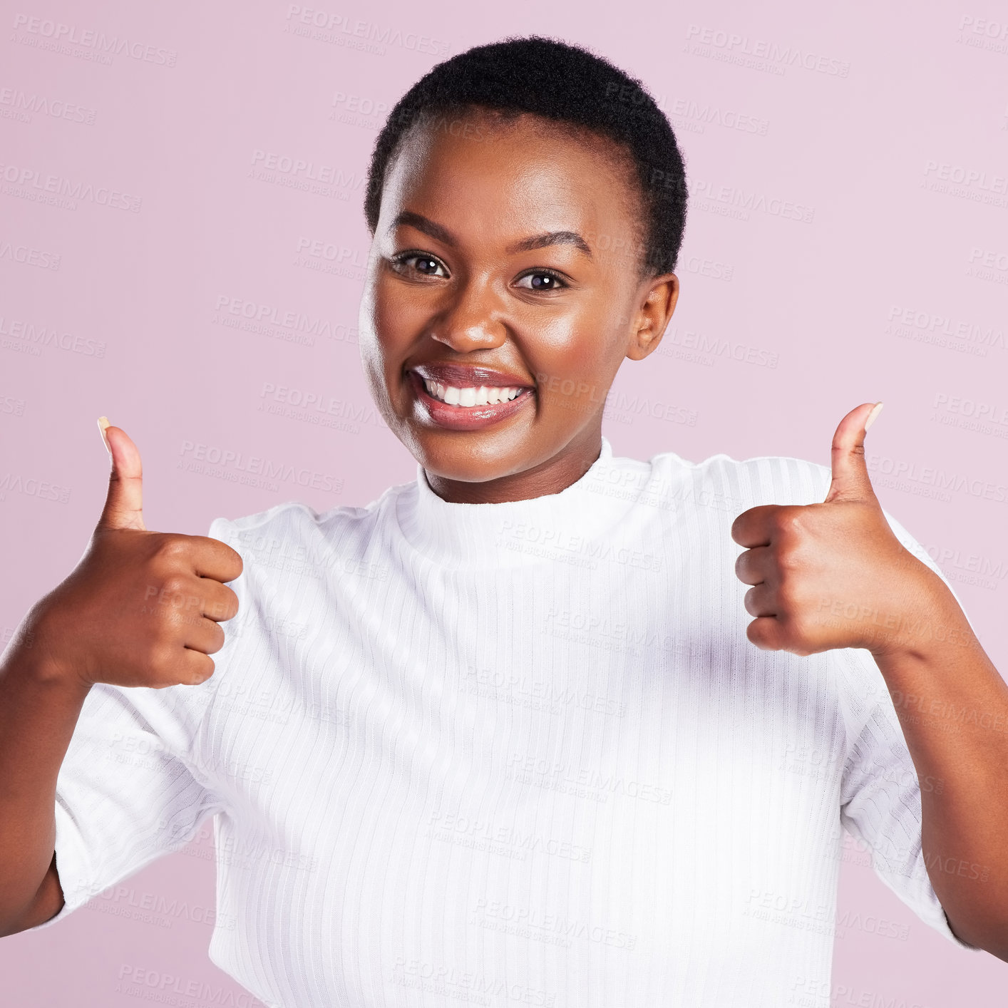 Buy stock photo Studio portrait of a young woman showing two thumbs up against a pink background