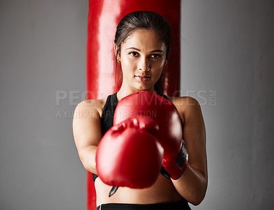 Buy stock photo Cropped portrait of an attractive young female boxer training in the gym