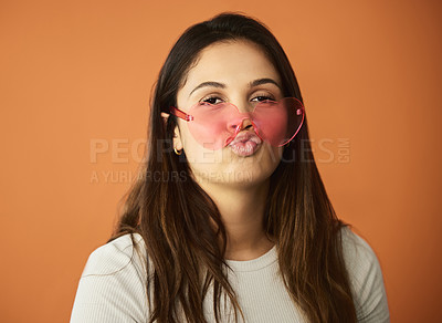 Buy stock photo Cropped portrait of an attractive young woman posing in studio against an orange background