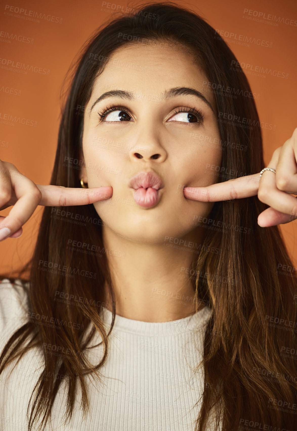Buy stock photo Funny face, fingers and woman in studio for humor, comedy or cheeks dimples on orange background. Female person, lips and playful gen z model for comic emoji, silly facial expression or joking mood