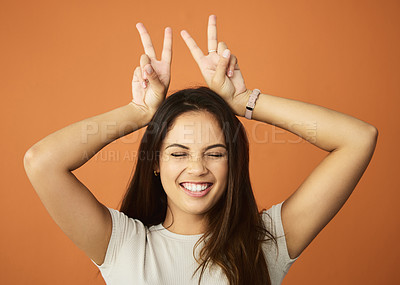Buy stock photo Cropped shot of an attractive young woman posing in studio against an orange background