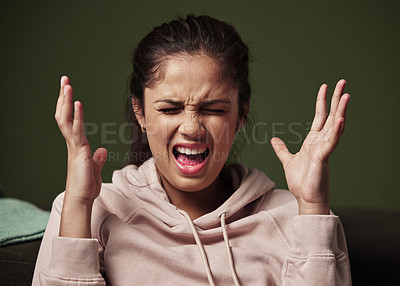 Buy stock photo Cropped shot of an attractive young woman screaming and looking frustrated against a green background