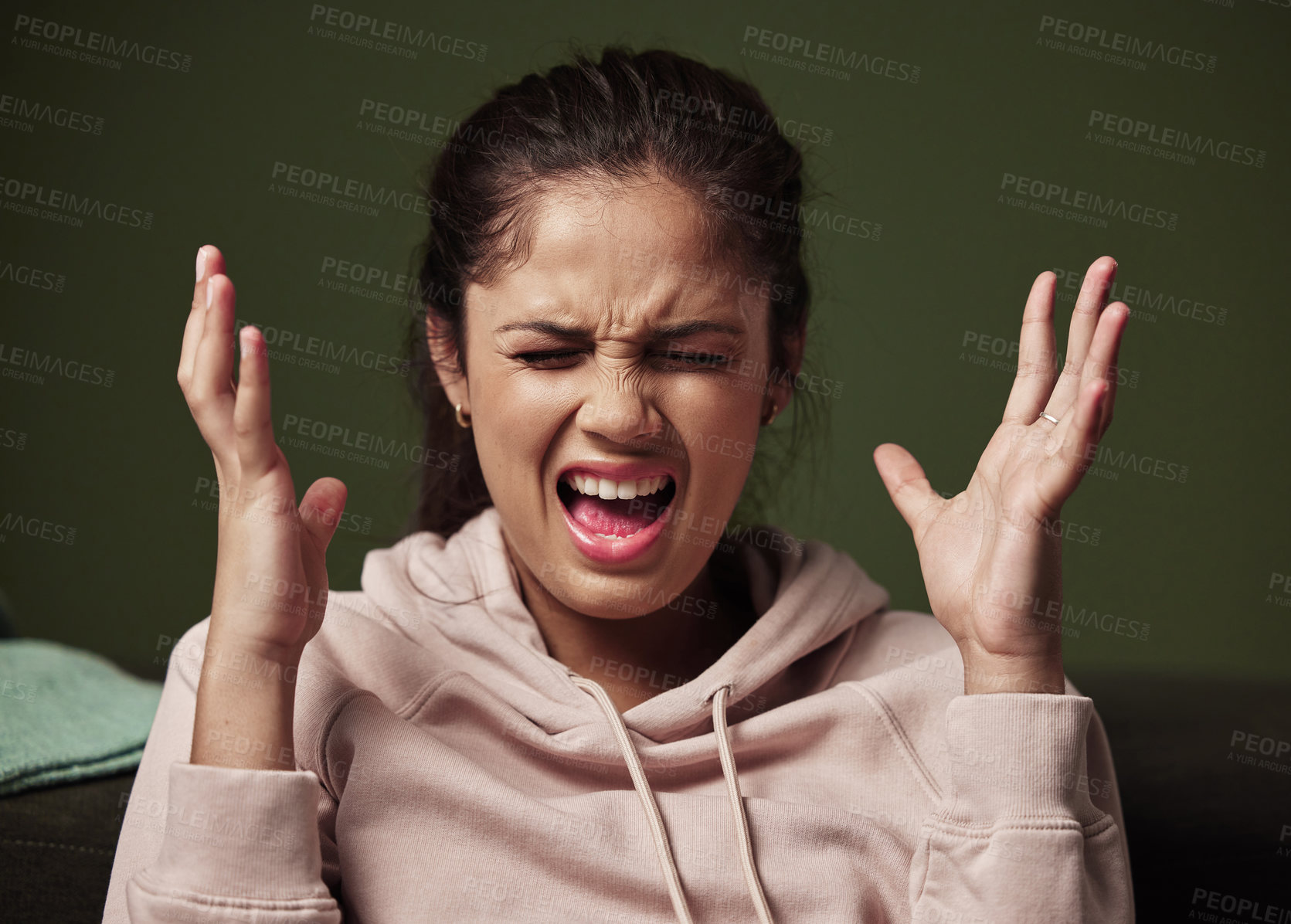 Buy stock photo Cropped shot of an attractive young woman screaming and looking frustrated against a green background