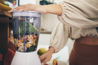 Buy stock photo Shot of a woman holding her blender while making a smoothie