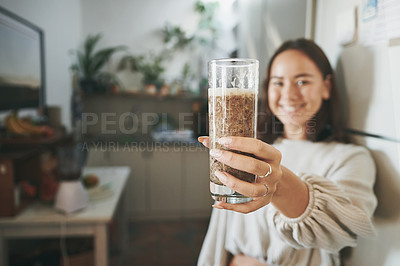 Buy stock photo Shot of a young woman holding her smoothie before drinking it