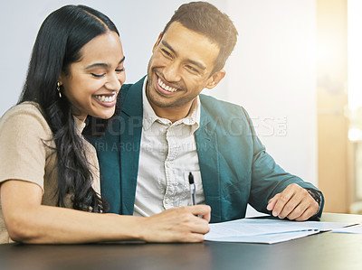 Buy stock photo Cropped shot of an affectionate young couple signing some financial paperwork