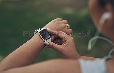 Buy stock photo Shot of a woman using her smartwatch during a workout
