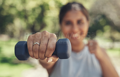 Buy stock photo Shot of a young woman holding a dumbbell for her workout