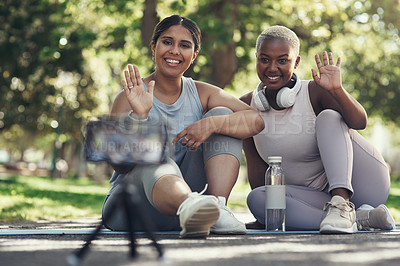 Buy stock photo Shot of two female friends taking a break to live stream their workout