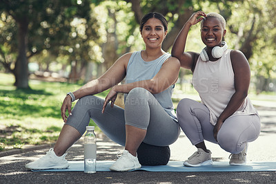 Buy stock photo Shot of two friends taking a break during their workout