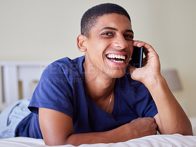 Buy stock photo Young man, happy conversation and phone call in bedroom, share funny story and laughing with contact at home. Mobile app, connection and comedy with casual chat, communication and student with gossip