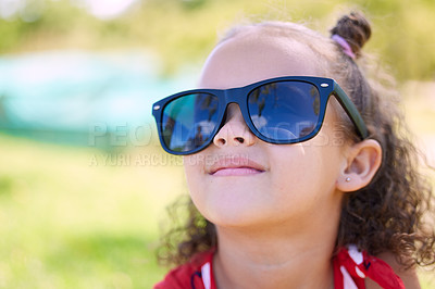 Buy stock photo Shot of an adorable little girl wearing sunglasses while at the park