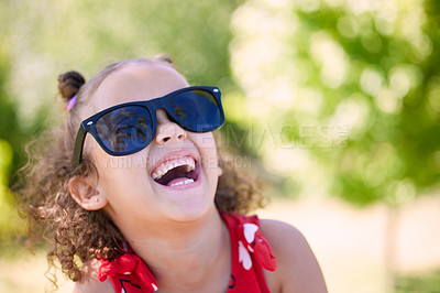 Buy stock photo Girl, child and laughing with sunglasses in park, garden or nature to relax on holiday in summer. Kid, happy and excited with thinking, joke and comic memory in sunshine with funny ideas on vacation