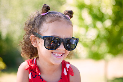 Buy stock photo Girl, child and laughing with sunglasses in garden, park or nature to relax on holiday in summer. Kid, smile and excited with thinking, joke and comic memory in sunshine with funny games on vacation