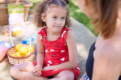 Buy stock photo Shot of an adorable little girl on a picnic at the park with her mother
