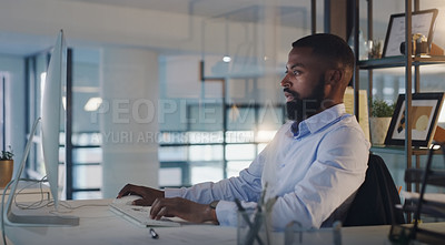 Buy stock photo Business man, focus and working on a computer at night while typing an email or report. A serious black male entrepreneur with technology for networking, internet connection and online research