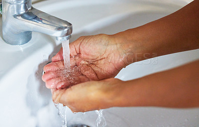 Buy stock photo Cropped shot of an unrecognizable male washing his hands in a hand basin at home