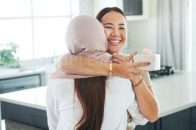 Buy stock photo Birthday, gift and smile with friends hugging in kitchen of home together for celebration or surprise. Box, present and wow with happy young women embracing in apartment for anniversary milestone