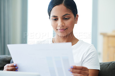 Buy stock photo Woman, documents and reading with paperwork for finance, budget planning or expenses on sofa at home. Young female person with smile for daily schedule, pay slip or checking bills on house or assets