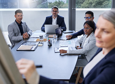Buy stock photo Shot of a group of businesspeople listening to a presentation in an office