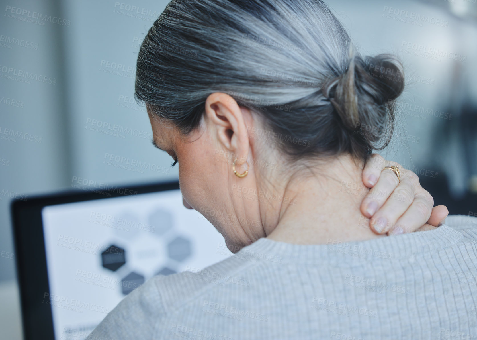 Buy stock photo Shot of a mature businesswoman sitting alone in the office and suffering from a sore neck