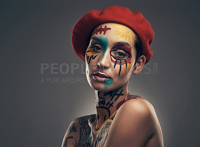 Buy stock photo Studio shot of a young woman posing with paint on her face on a grey background