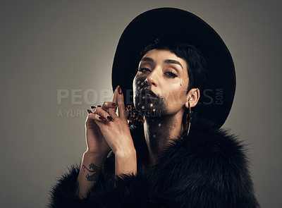 Buy stock photo Studio shot of a young woman posing with paint on her face on a grey background