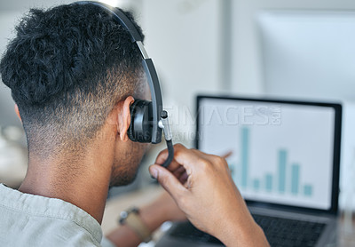 Buy stock photo Shot of an unrecognizable salesman sitting alone in his office and wearing a headset while using his laptop
