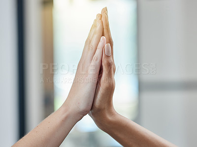 Buy stock photo Closeup shot of two unrecognisable businesspeople giving each other a high five in an office