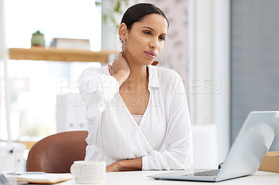 Buy stock photo Shot of a young businesswoman sitting at a desk looking tired in a modern office