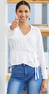 Buy stock photo Shot of a young businesswoman showing a thumbs up in a modern office
