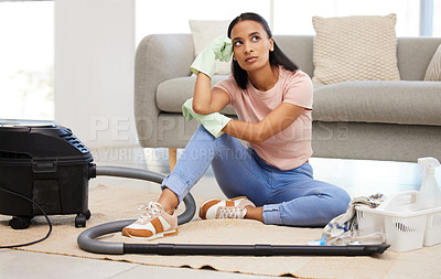 Buy stock photo Shot of a young woman sitting on the floor looking contemplative at home
