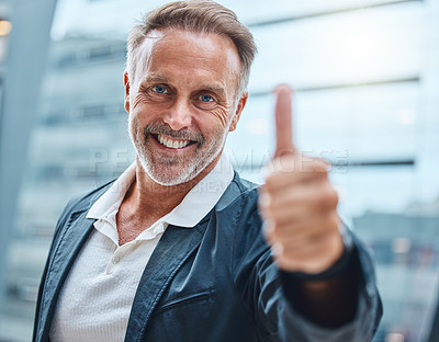 Buy stock photo Shot of a mature businessman showing thumbs up against an urban background
