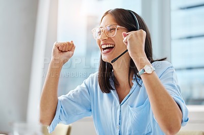 Buy stock photo Shot of an attractive young call centre agent sitting alone in her office and feeling successful