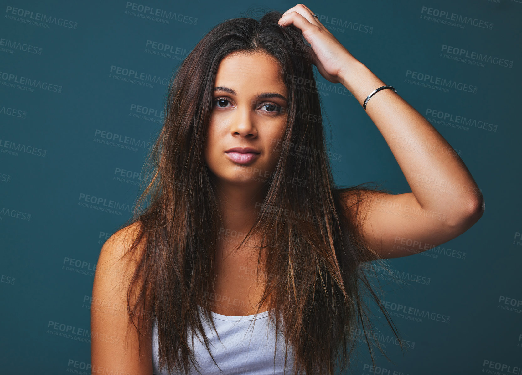 Buy stock photo Portrait shot of a beautiful young woman posing against a blue background