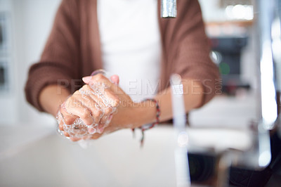 Buy stock photo Cropped shot of an unrecognizable woman washing her hands at home