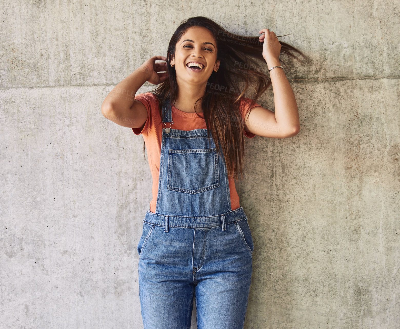 Buy stock photo Portrait of a beautiful young woman tossing her hair and laughing against an urban background