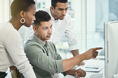 Buy stock photo Shot of three colleagues having a discussion in a modern office