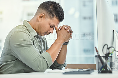 Buy stock photo Shot of a businessman looking stressed while sitting at his desk