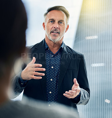 Buy stock photo Shot of a businessman giving his staff a training seminar