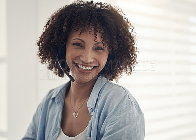 Buy stock photo Shot of an attractive young sitting alone at home and wearing headsets