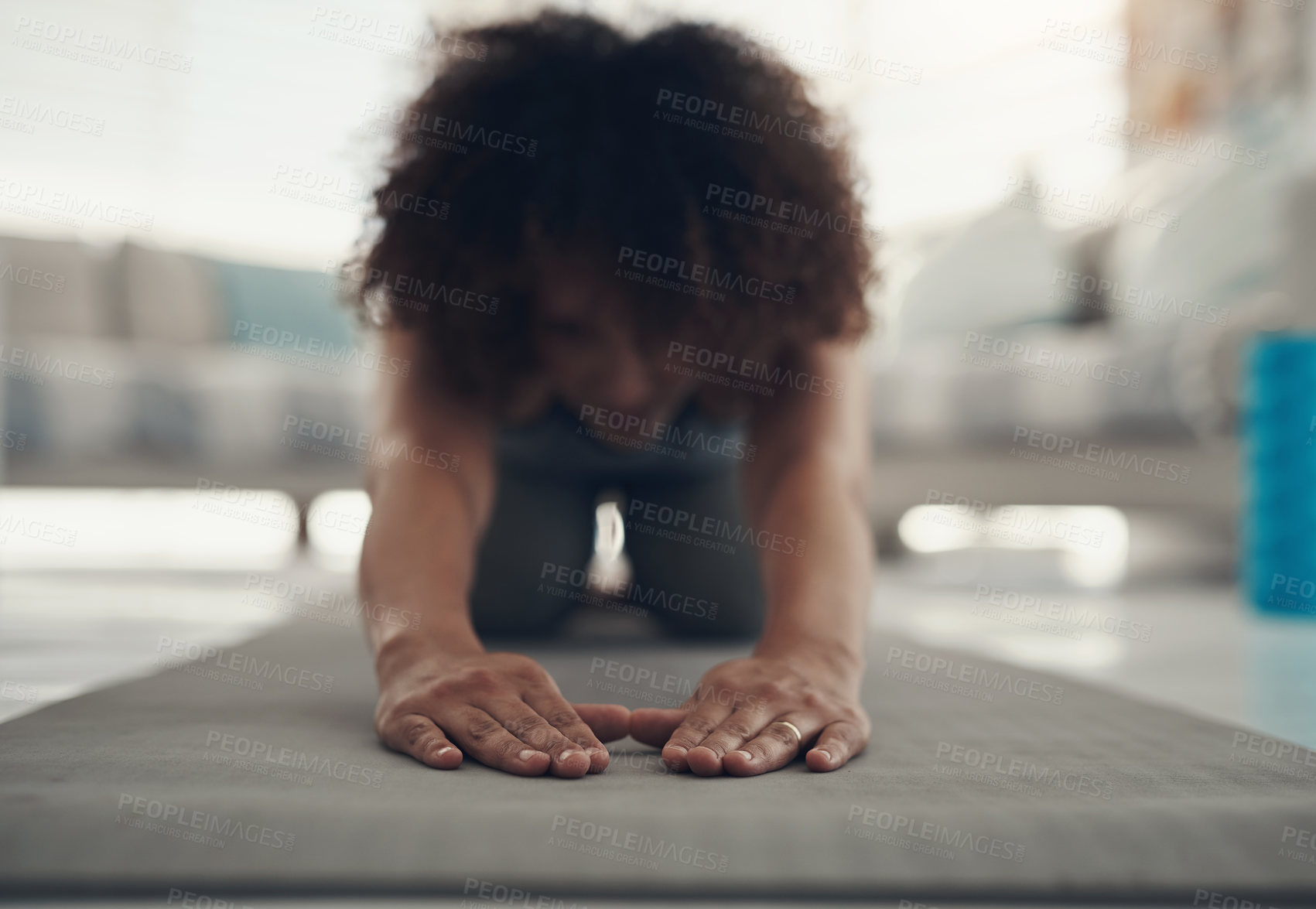 Buy stock photo Defocused shot of a young woman practising yoga in her living room