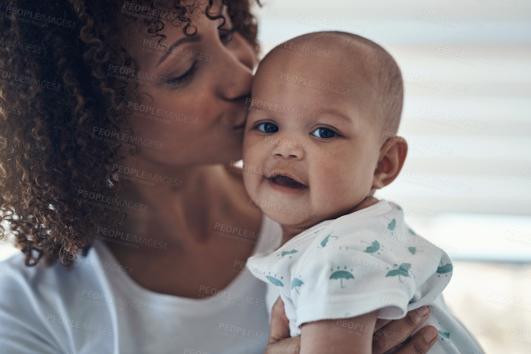 Buy stock photo Shot of a young woman kissing her adorable baby girl at home