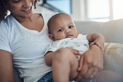 Buy stock photo Shot of a young woman relaxing with her adorable baby girl on the sofa at home