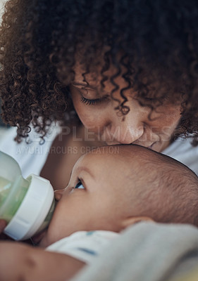 Buy stock photo Shot of an adorable baby girl being bottle fed by her mother on the sofa at home